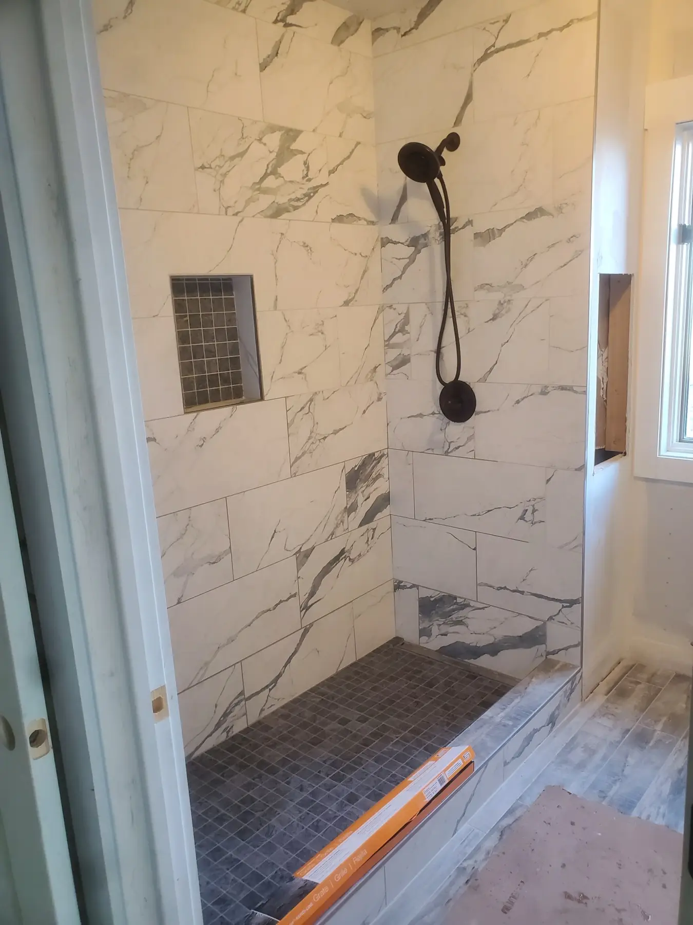 Marble tile shower with bronze fixtures